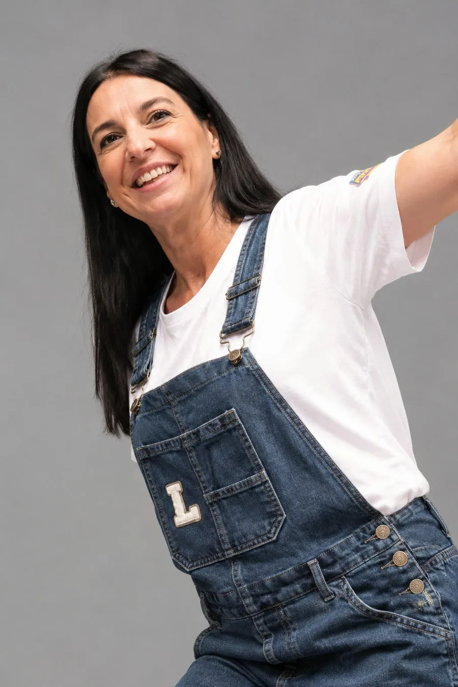 Retrato de Lourdes sonriendo con el peto vaquero con la letra L de Lou